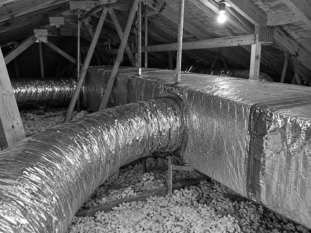 Duct trunk and branches crossing a hot attic above blown insulation